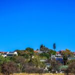 Attractive, modern suburban home on the Northshore with a manicured lawn under a bright, clear sky, representing a desirab...