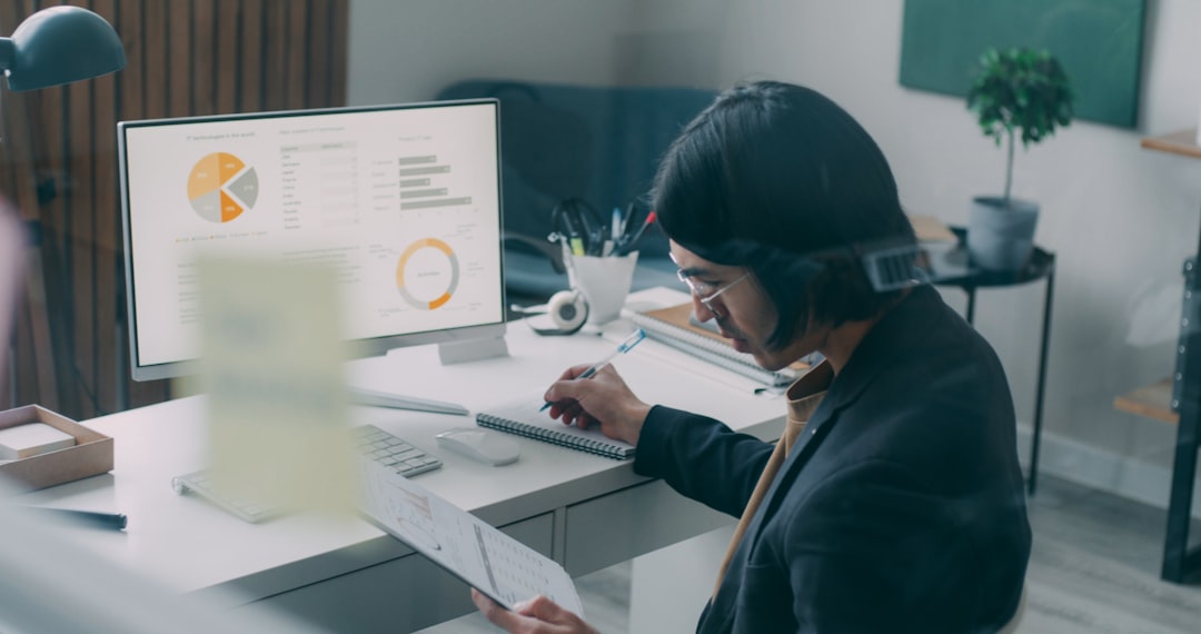 A professional person in a modern office analyzes complex data and charts on a futuristic transparent screen, illustrating the role of AI in shaping future real estate transactions.