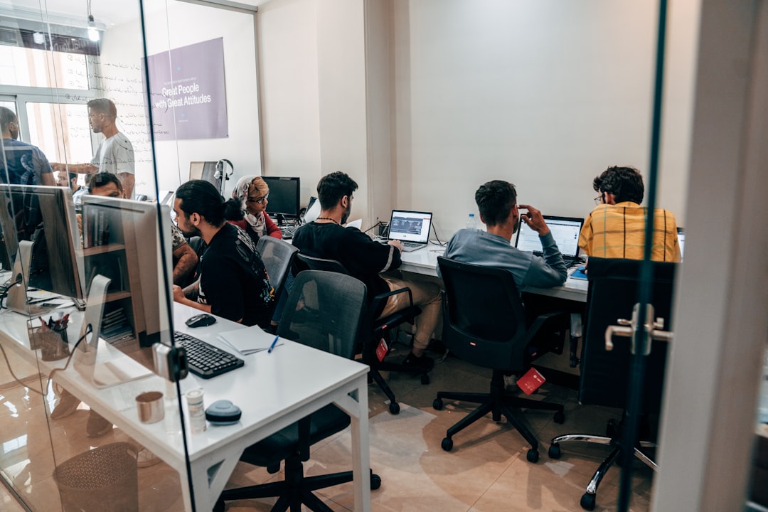 A diverse team of professionals sits around a conference table in a bright, modern meeting room, looking disengaged and frustrated, illustrating the impact of mental clutter on team productivity.